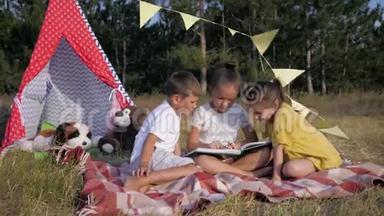 可爱的孩子们、可爱的女孩子和漂亮的<strong>男孩</strong>在<strong>树林</strong>里野餐时喜欢书上的故事
